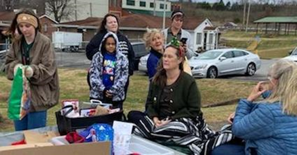 Group of Ladies and a child handing out gifts