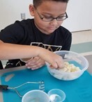 young boy mixing in a bowl