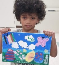 child holding up a painting