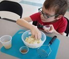 little boy with glasses doing a craft