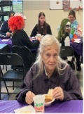 Various residents are seated at tables and enjoying their bowls of chili.