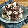 A plate of oreo balls is sitting on a folded up dish towels. 