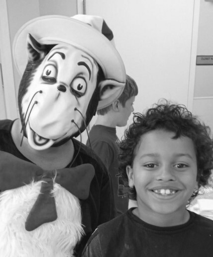 A boy standing with a person in a cat in the hat costume.