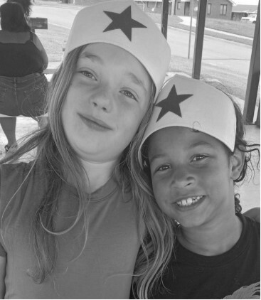 Two children wearing hats with stars on the front.